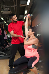 Brunette woman working out with personal trainer