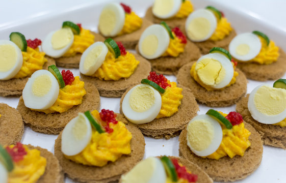 Dish with delicious appetizers with carrots cream, eggs and red caviar