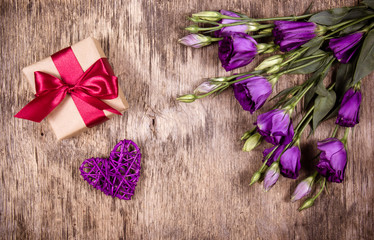 Gift box with bow and purple flowers. Eustoma. Wicker heart. St. Valentine's Day