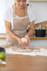 Female hands making dough for pizza or bread while using rolling pin. Baking concept