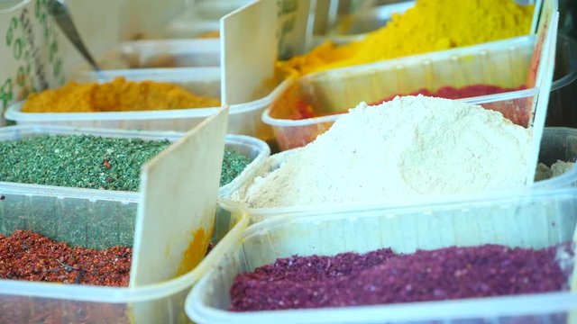 Spices, nuts, dried fruits on display at market on the counter, 4k, slow-motion