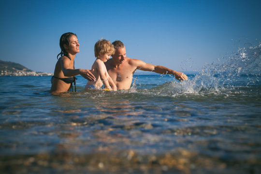 Happy family jumping together on the beach. Family concept. Pool. Vacation.Summer time. Summer. 