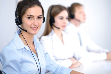 Call center. Focus on beautiful business  woman in headset