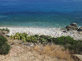 A rocky coast piece where people sunbathe and bathe. Nature unpolluted, green water near the beach