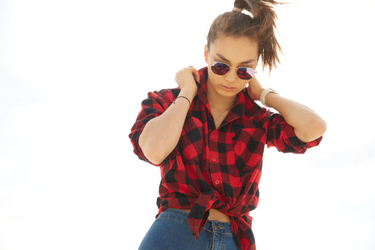 Asian girl in sunglasses and red squared shirt in the sun