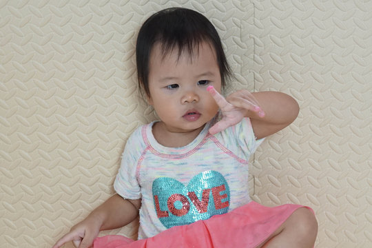 Little asian toddler girl 1 year 7 months old play pink dought color at home. Selective focus