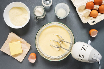 The process of preparation of the manna in the kitchen. Ingredients: semolina, sugar, yogurt, oil, eggs. Mix ingredients with a mixer. The view from the top.