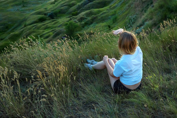 Female hiker sitting on the edge of hill