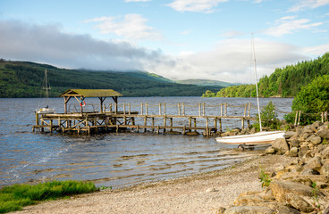 A small pebble beach and a wooden jetty in Loch Tay