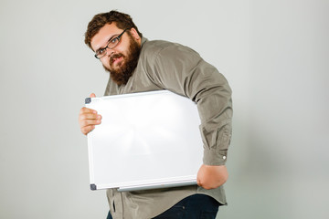 Happy smiling young business man showing blank signboard, isolated on white background