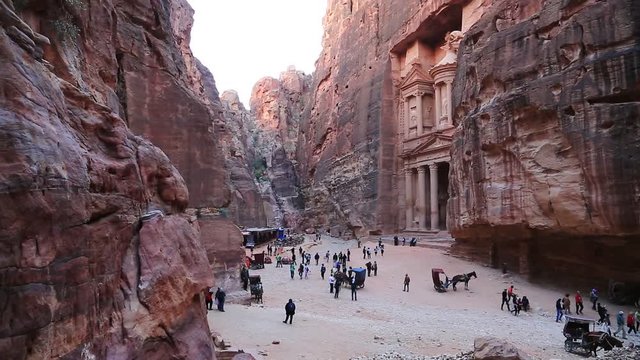 People and animals near Al Khazneh or the Treasury at ancient Petra, originally known to Nabataeans as Raqmu - historical and archaeological city in Hashemite Kingdom of Jordan
