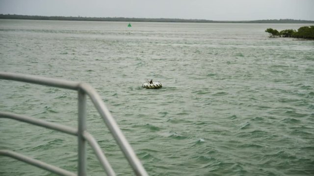 A long shot of a random white wheel floating in the sea. The shot is taken under a gloomy weather.
