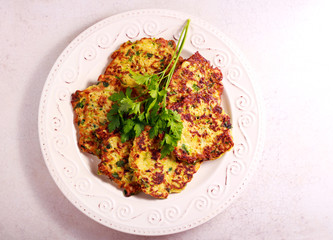 Zucchini and parsley fritters on plate