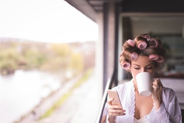 Bride using mobile phone while having a coffee