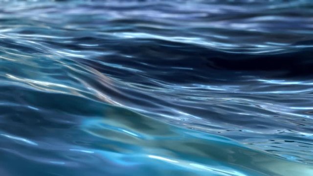 Waves on the water surface. Reflection of light, variations of blue and cyan. Caustics in refraction.