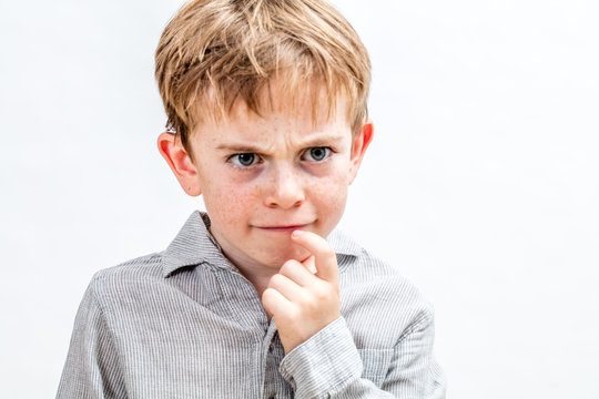 mischievous kid with frowning freckles having doubt for serious solution