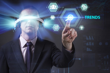 Business, Technology, Internet and network concept. Young businessman working in virtual reality glasses sees the inscription: Trends