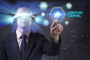 Business, Technology, Internet and network concept. Young businessman working in virtual reality glasses sees the inscription: Venture capital