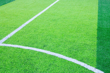 Fototapeta premium Photo of a green synthetic grass sports field with white line shot from above