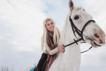 Nice girl and white horse outdoor in a winter