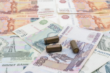 Three bullets lie on Russian money close up