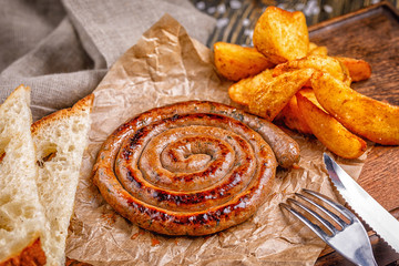 Spiral sausage grilled. with golden crispy delicious french fries. Fast food in the restaurant. Delicious fried spiral sausages.