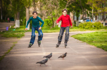 Three children on in line skates in park