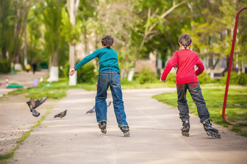 Three children on inline skates in park