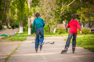 Three children on in line skates in park