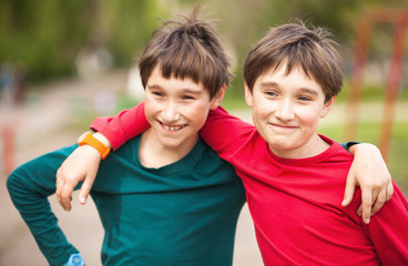 Two smiling twin brothers outdoor portrait