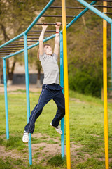 Obraz premium Happy kid boy on top of gymnastics ladder