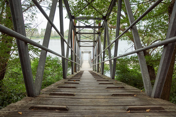 Wood and metal footbridge on the river in autumn