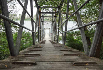 Wood and metal footbridge on the river in autumn