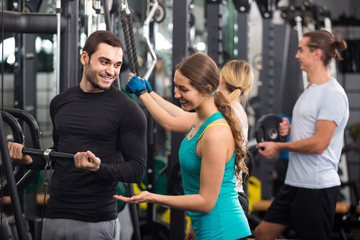 Fototapeta na wymiar Adults having strength training under coach control in gym