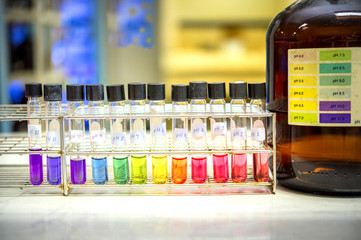 Preparation of standard pH solution, Matching the color of the bottle with the Universal Chemical Indicator in chemistry laboratory. Close up image.
