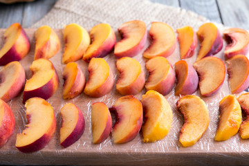 Pieces of peaches on a cutting board for freezing