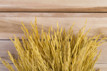 Top view golden rice on wood floor background.
