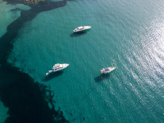 Vista aerea di barche ormeggiate che galleggiano su un mare trasparente. Immersioni relax e vacanze estive. Coste francesi, Corsica. Francia