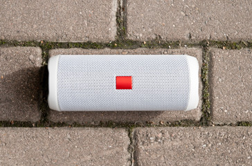 White speaker on a granite background. The view from the top. Outdoors in Sunny weather.