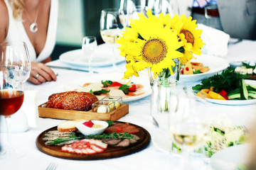  dish with delicacies and a vase with sunflowers on a festive table