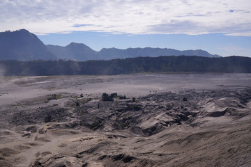 Panoramic view from  the top of the stairs heading towards the dusty valley behind hindu temple at the foot of mount Batok at the Tengger Semeru National Park in East Java, Indonesia.