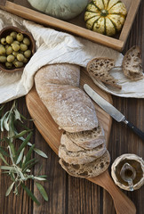Italian ciabatta bread, olives and olive oil - Mediterranean table on rustic wooden background. Top view, close up