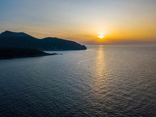 Vista aerea della costa della Corsica al tramonto, promontori che costeggiano il mare. Penisola di Cap Corse. Francia