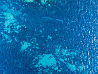Vista aerea di scogli sul mare. Panoramica del fondo marino visto dall’alto, acqua trasparente. Fondo marino disegnato dalle alghe