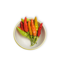 Bowl of different colors of chilli peppers  isolated on white background.