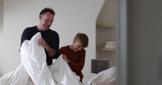 Father and Son making a bed
