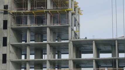 Building construction site work against blue sky. Workers at the construction site of an apartment building