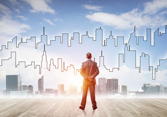 Motivation and inspiration concept with modern cityscape and businessman observing it