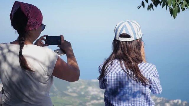 Two friends admire the panorama of the city and take pictures on the phone. HD, 1920x1080, slow motion.