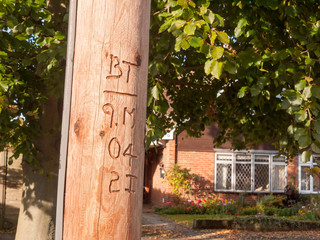 carved wooden electrical post outside lettering numbering
